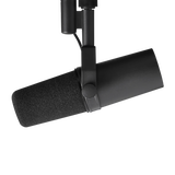 Micrófono Shure SM7B negro en soporte de horquilla, vista lateral en ángulo